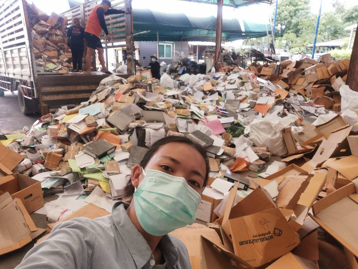 กองเศษกระดาษและกล่องลูกฟูกรอคัดแยกขึ้นรถบรรทุก