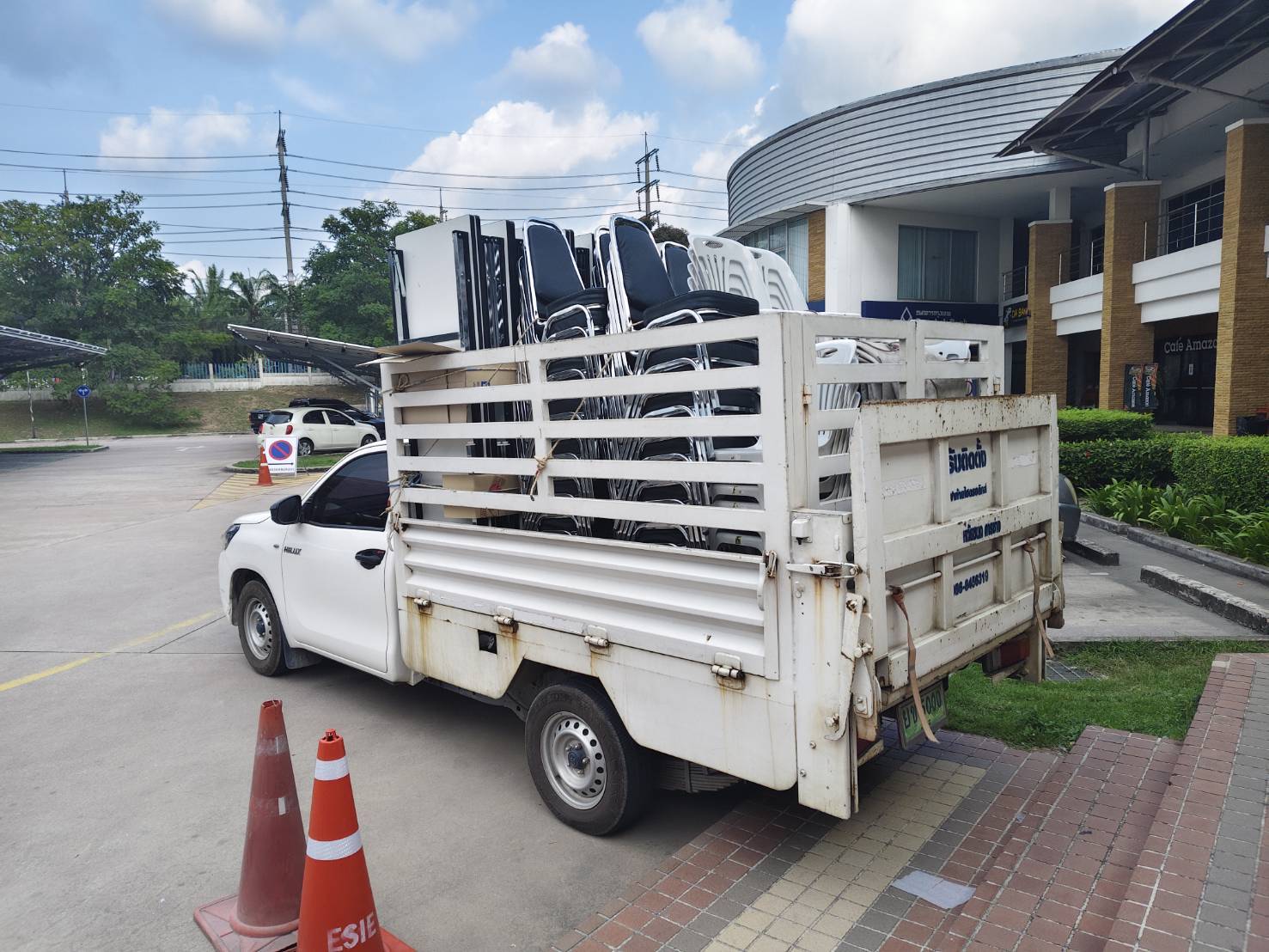 รถกระบะบรรทุกเก้าอี้และโต๊ะเพื่อจัดส่งถึงหน้างาน