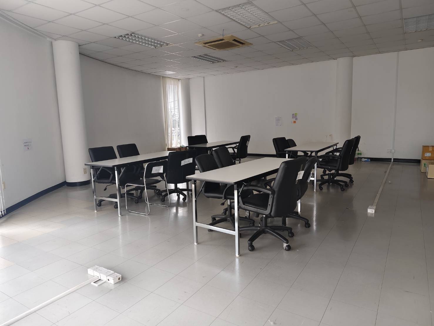 โต๊ะหน้าขาวและเก้าอี้สำนักงานจัดวางในห้องประชุม